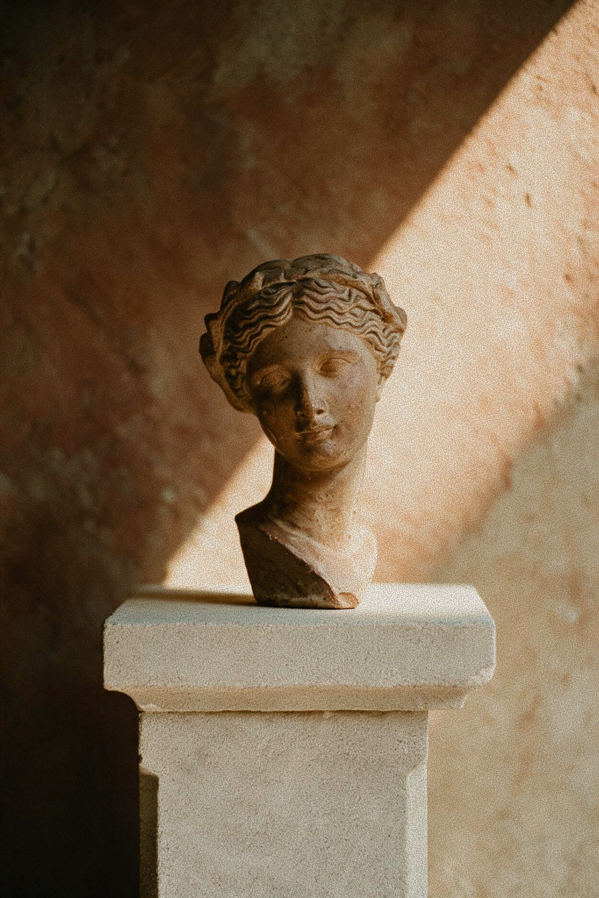 Weathered stone bust sculpture symbolizing the sculpting, lifting results of the Buccal & Glow facial massage at Skincuress in Hoboken, NJ
