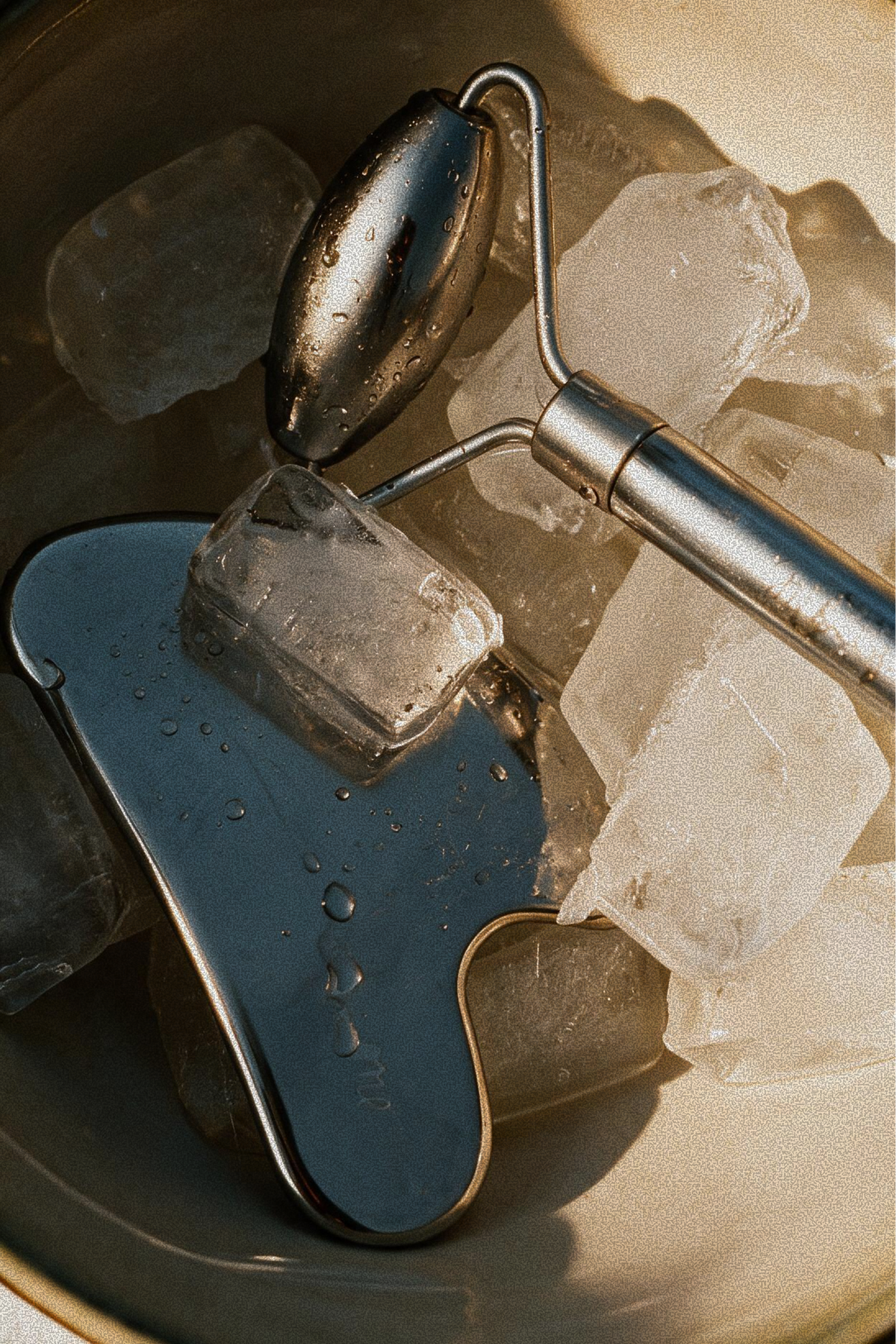 Gua Sha tool and facial roller chilled in ice, used for lymphatic massage during the Somatic Sculpt treatment at Skincuress in Hoboken, NJ